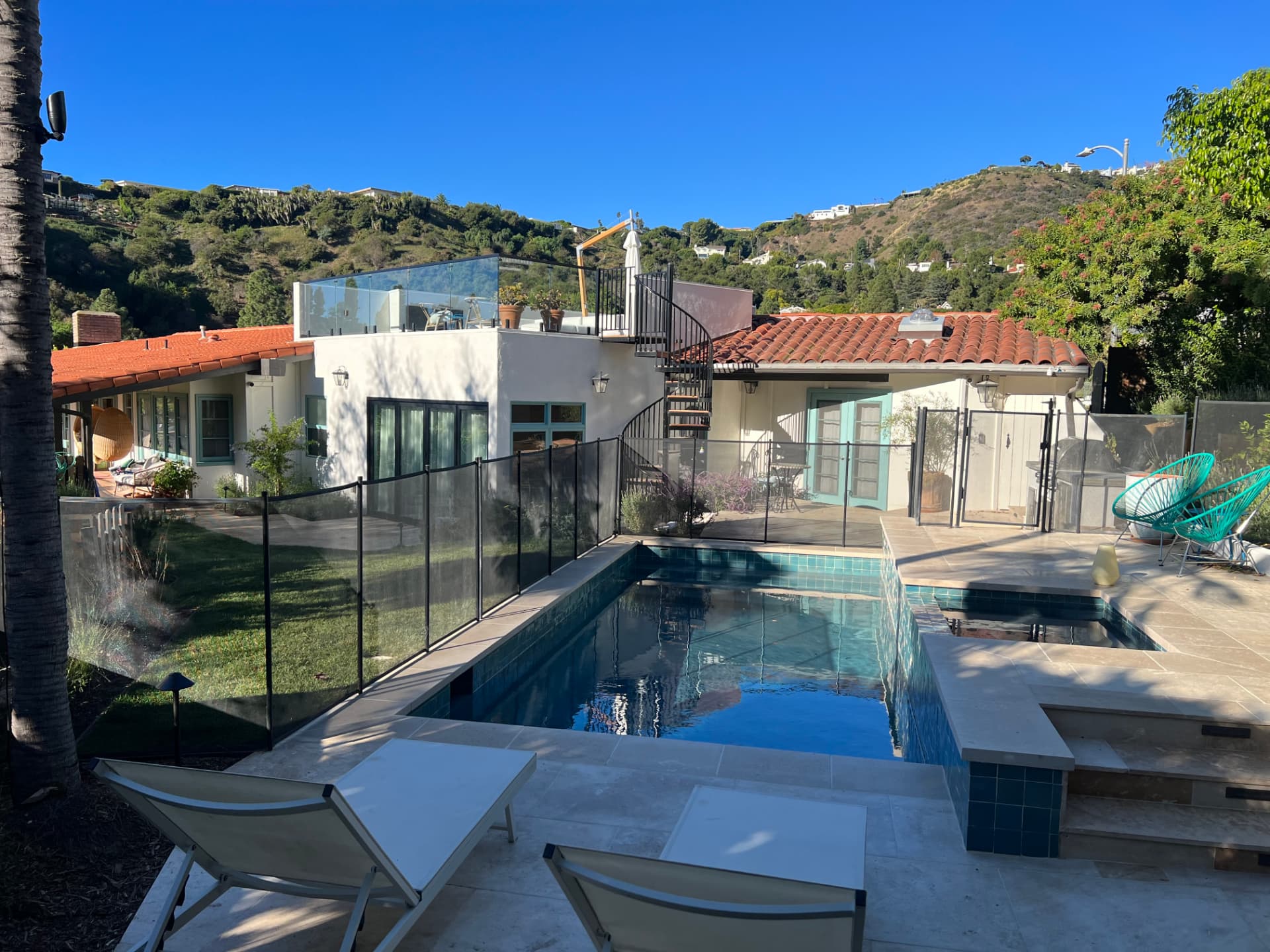 Pacific Palisades backyard pool with hillside views and spiral staircase