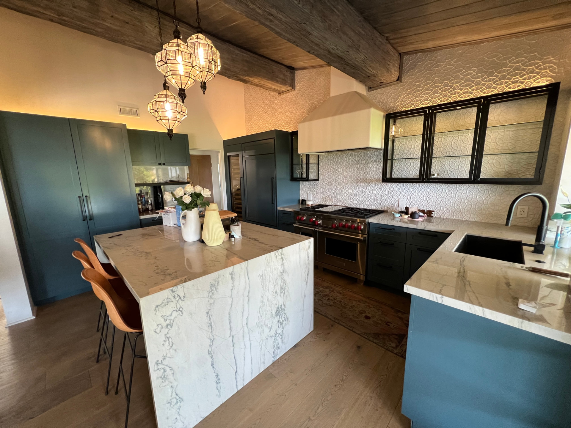 Pacific Palisades kitchen with marble waterfall island and dark green cabinetry