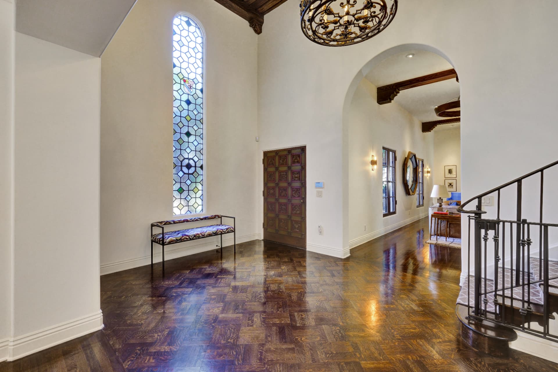 Hancock Park grand foyer with carved door and stained glass window
